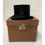 An antique moleskin top hat by College Hatters Collins & Son, Winchester, within a tan leather hat