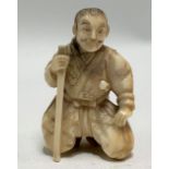 Meiji period Japanese ivory carved netsuke in the form of a kneeling gentleman with stick, height