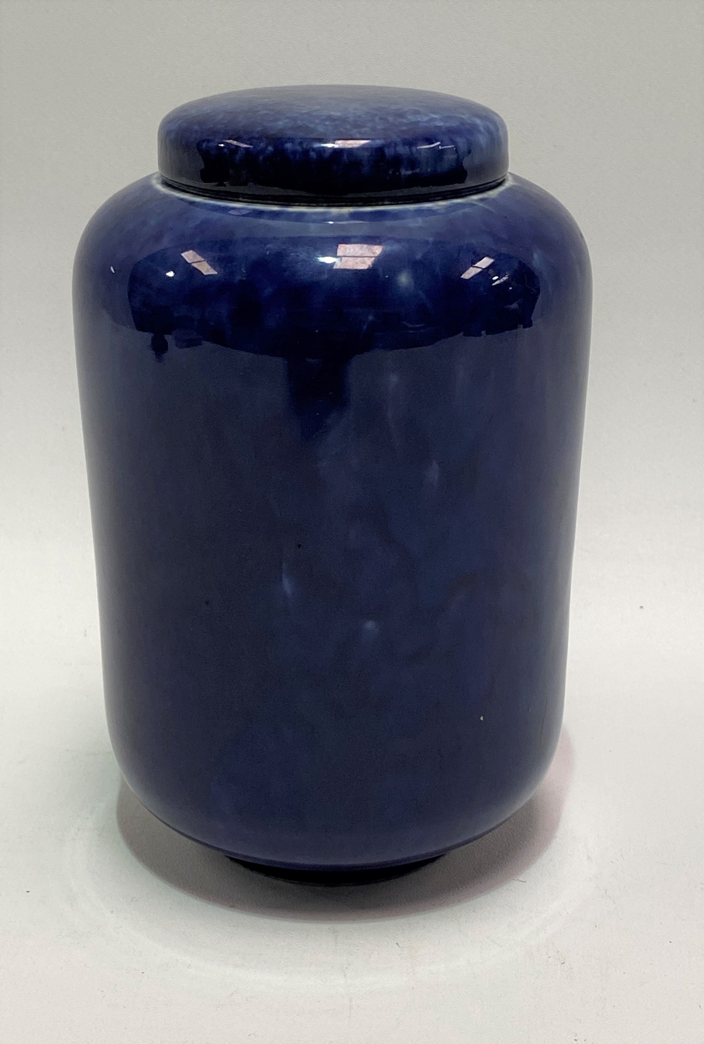 A Ruskin Pottery blue soufflé glaze cylindrical jar and cover, impressed marks to the base and No.