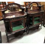 A pair of Victorian mahogany mirror-back display cabinets, the raised backs with a shaped bevel