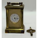 A brass cased French miniature carriage timepiece with original velvet travel case, the 10mm white
