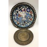 A Persian copper and enamel circular dish decorated with a warrior on horseback amongst foliate