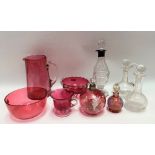 Five Victorian cranberry glass items, including two enamel decorated scent bottles and stoppers;
