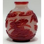 Chinese Beijing glass ovoid snuff bottle, red overlay and carved decoration with a stalk, bats and
