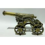 Brass model cannon with 30in barrel and on dragon cast carriage with four wheels, length overall
