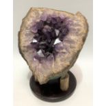 An amethyst geode upon stand, height of geode 15cm
