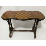 A Victorian walnut and parquetry inlaid games table, the moulded top with chequerboard and flanked