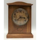 An oak cased German two-train mantle clock with 5in dial with black Arabic Numerals and within an