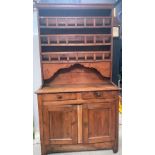 A French pine dresser, the raised back with three fixed shelves with galleries over a shaped