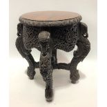 Burmese hardwood circular stand with carved cabriole legs with elephant head hips and with a foliate
