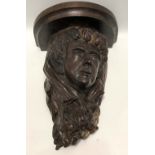 A good carved oak wall bracket, carved with the face of a gentleman with garland headpiece and
