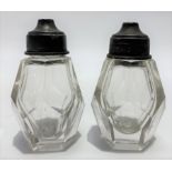 A pair of Edwardian silver hinge lidded facet cut glass salt shakers, maker William Hutton & Sons