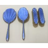 A George V silver and blue guilloche enamel four piece dressing table set, comprising hand mirror,