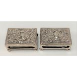 Pair of Victorian silver foliate scroll embossed matchbox cases raised on four ball feet, maker J.J,