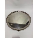 A heavy George VI silver salver with pie crust beaded edge and raised on four ball and claw feet