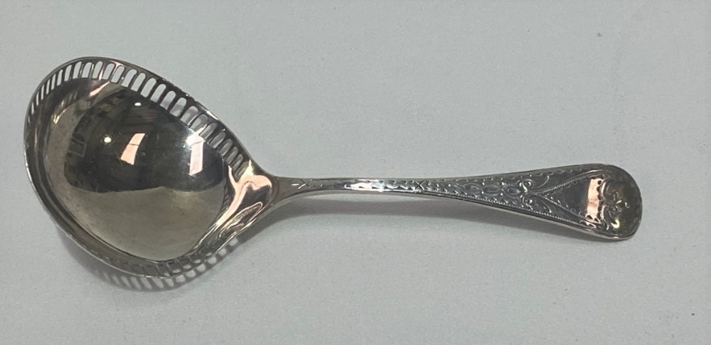 An Edwardian Britannia standard silver caddy spoon, the handle with bright cut decoration, the