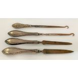 Four dressing table implements with silver weighted handles, to include a set of three and another.