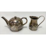 An Egyptian white metal niello ovoid teapot and matching milk jug, both decorated with river