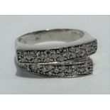 A modern 18ct white gold diamond set crossover ring, stamped 18ct, size M, weight 4.9g approx.