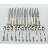 A Swedish white metal set of twelve fruit knives and spoons, the steel blades stamped Raadvad,