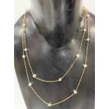 Yellow metal and pearl long necklace, the necklace with twenty separated blister pearls, length