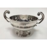 An Edwardian silver twin handled trophy cup by Alstons & Hallam, of pedestal form with flying scroll