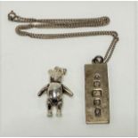 A silver ingot pendant necklace together with a 925 silver articulated teddy bear pendant, weight
