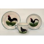 A Wemyss ware black cockerel decorated trio, impressed and printed marks and retailed for T. Goode &