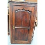 George III oak wall-hanging corner cupboard, the hinged door with fielded panels, height 129cm