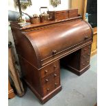 A Victorian mahogany roll-top desk, the cylinder roll-top enclosing three drawers and six