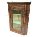 A small rustic 19th Century oak wall-hanging corner cabinet with glazed door, height 67cm x width