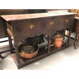 An oak small dresser base with three drawers over three ring turned baluster supports and an open