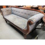 19th Century mahogany framed button back upholstered settee with scroll arms and raised on turned