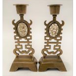 A pair of Chinese brass candlesticks with oval jadeite foliate carved and pierced panels, height