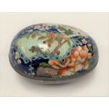 A Japanese cloisonné oval box and cover decorated with blossoming prunus and chrysanthemum upon a