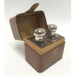 Leather cased pair of rectangular section glass scent bottles with silver plate screw lids, height