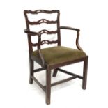 A George III mahogany elbow chair with ladderback and scroll arms over a drop in upholstered seat,