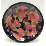Moorcroft pomegranate pattern tube lined dish upon a blue ground, diameter 21.5cm, signed and with