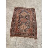 Eastern wool rug with three lozenges and floral design within borders, 155cm x 110cm (af).