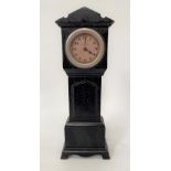 A novelty ebony timepiece in the form of a long case clock and with 1.75in dial, height 26.5cm