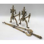 Pair of brass cast fire dogs with urn twin handled finials; together with a pair of fire tongs.