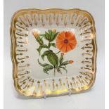 An early 19th century porcelain square section dish with serpentine rim, the well floral