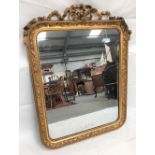 A 19th Century gilt gesso framed rectangular wall mirror, with ribbon applied surmount, the frame