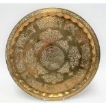 An Islamic brass tray embossed with inscriptions, diameter 32cm.