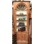 A George III style pine corner cupboard, the barrel back with three fixed serpentine shelves over