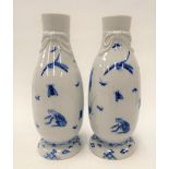Pair of Japanese blue and white underglaze pedestal bottles, the neck with ribbon moulding, the body