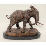 A modern bronze sculpture of a bull elephant upon a naturalistic oval base and with black marble