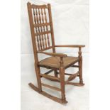 An ash and elm rush seated ladderback rocker chair, height 105cm.
