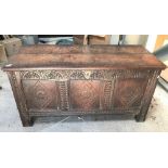 An 18th century oak coffer, the two plank top with moulded edged over a three panelled front with