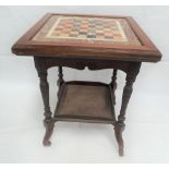 A Victorian mahogany two tier square section games table inset with a specimen stone chequer